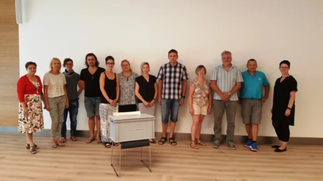 Bärbel Uhlenhaut von der Stadtwerke Halle GmbH (links) und Sandy Krüger von der bildungszentrum energie GmbH (rechts) überreichen den Lehrkräften „ihrer“ Projektschulen die Boxen mit den Unterrichtsmaterialien für den Technikunterricht.